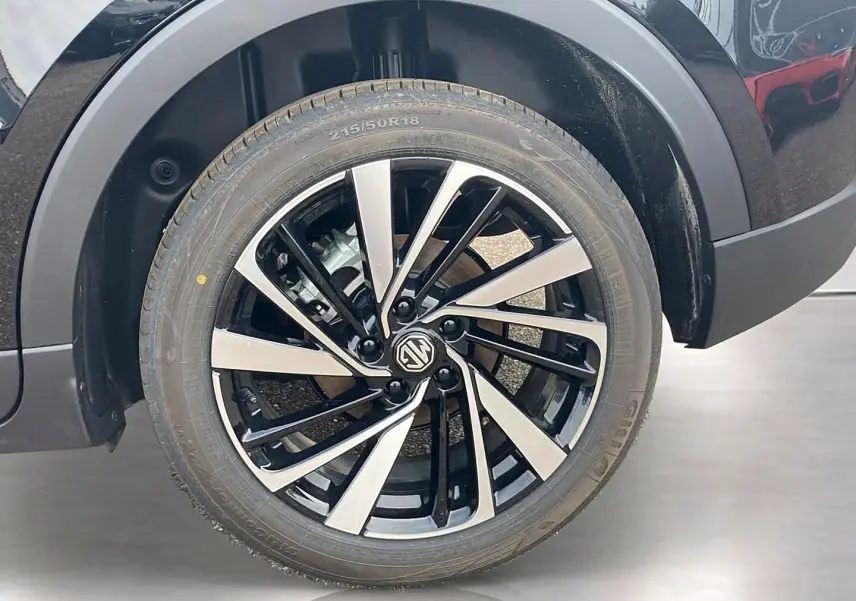 Gros plan sur la roue avant droite noire avec jante alu bicolore du MG Motor ZS 1.5 hybrid 197 luxury 2026.