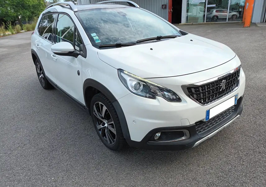 Peugeot 2008 blanc vue 3/4 avant droit, avec jantes alliage noires et toit ouvrant visible.