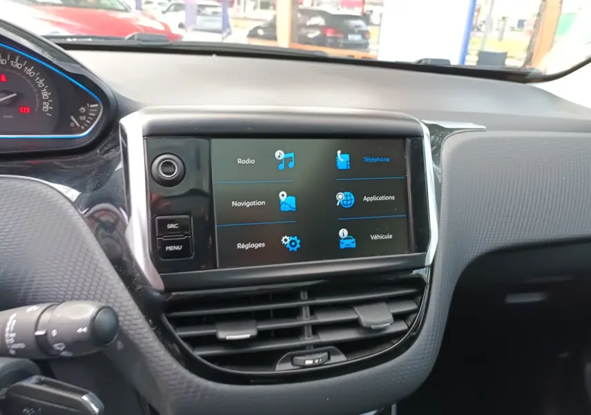 Vue intérieure du tableau de bord du Peugeot 2008 blanc, avec écran tactile central affichant les options multimédia.