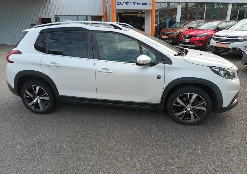 Profil droit d'un Peugeot 2008 blanc 2018 version PureTech 130 Crossway avec jantes alliage et barres de toit.
