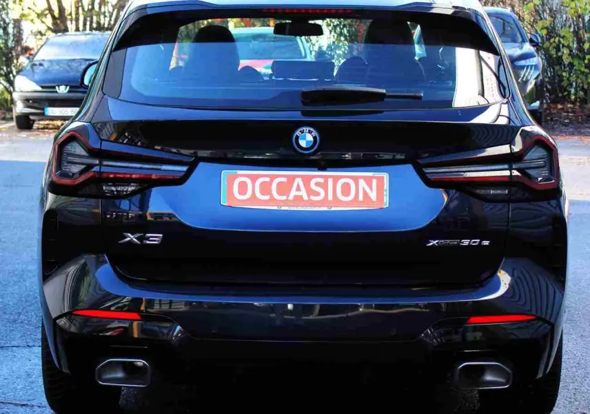 Vue arrière d’un BMW X3 xDrive 30e hybride rechargeable 2023 en bleu métal avec logo et feux LED distinctifs.
