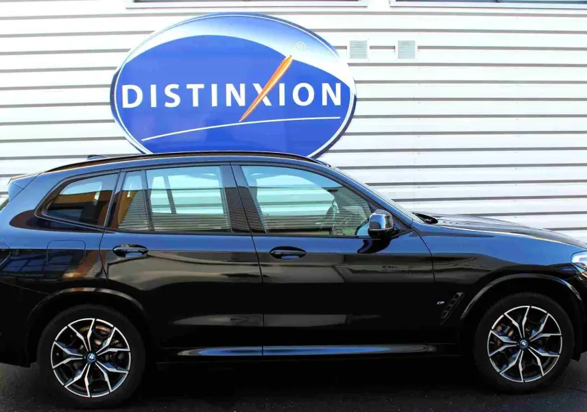 BMW X3 xDrive 30e 2023 en bleu métal, vue profil côté gauche avec jantes alliage M Sport distinctives.