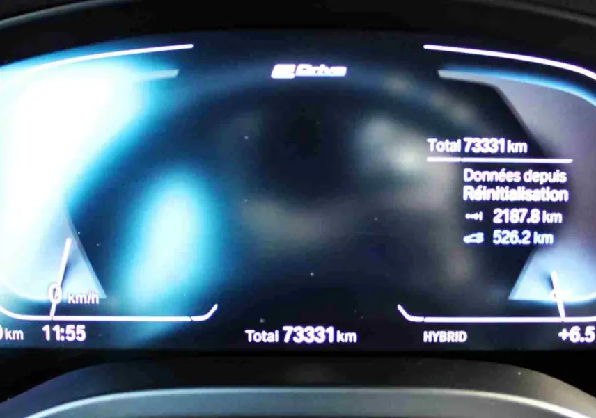 Tableau de bord numérique du BMW X3 xDrive 30e 2023 affichant 73 331 km, température et autonomie hybride.
