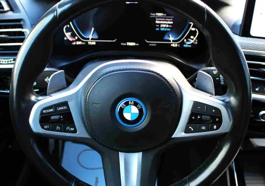 Vue rapprochée du volant M Sport en cuir noir du BMW X3 xDrive 30e hybride rechargeable 2023 avec commandes intégrées.