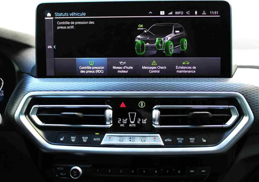 Écran central du tableau de bord du BMW X3 xDrive 30e 2023 montrant le contrôle pression pneus avec interface moderne.