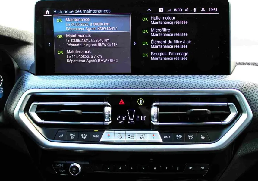 Tableau de bord du BMW X3 xDrive 30e 2023 avec écran multifonction et commandes climatisation visibles.