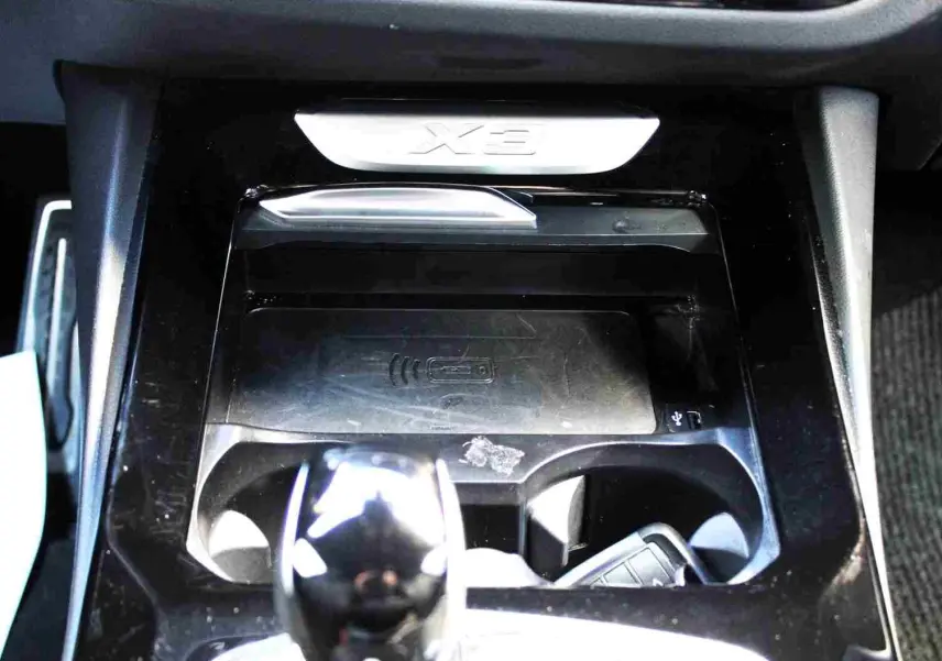 Gros plan sur la console centrale du BMW X3 xDrive 30e 2023 avec levier de vitesses et logo X3 en relief.