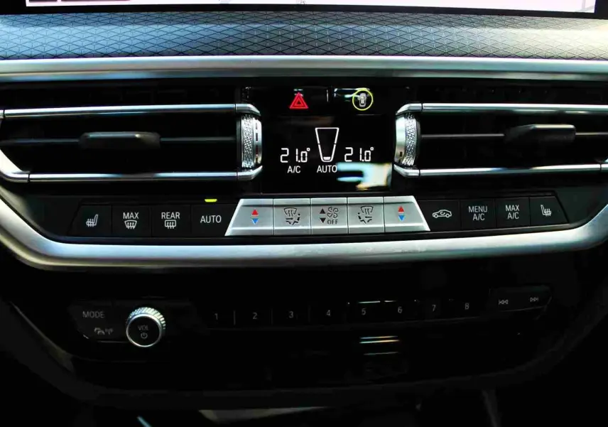 Détail du tableau de bord du BMW X3 xDrive 30e 2023 montrant la climatisation automatique et les commandes de ventilation.