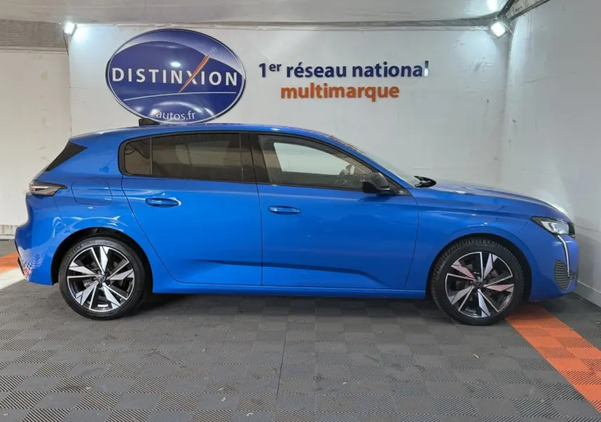 Peugeot 308 PureTech 130 S&S Allure Pack bleu vue de profil côté gauche en intérieur showroom.