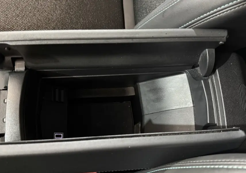 Vue plongeante sur le rangement central ouvert de la Peugeot 308 bleu, intérieur noir avec surpiqûres bleues.