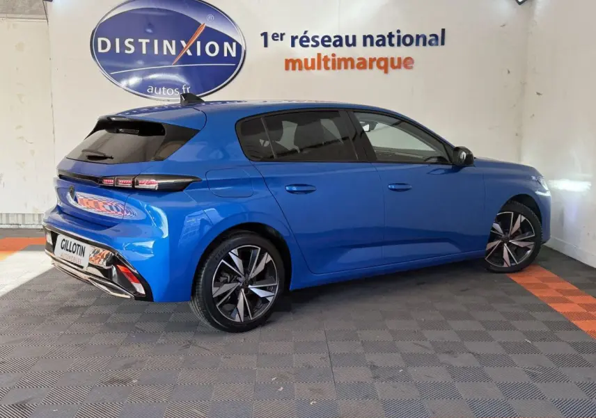 Peugeot 308 PureTech 130 S&S Allure Pack bleu vue 3/4 arrière droit en intérieur showroom.