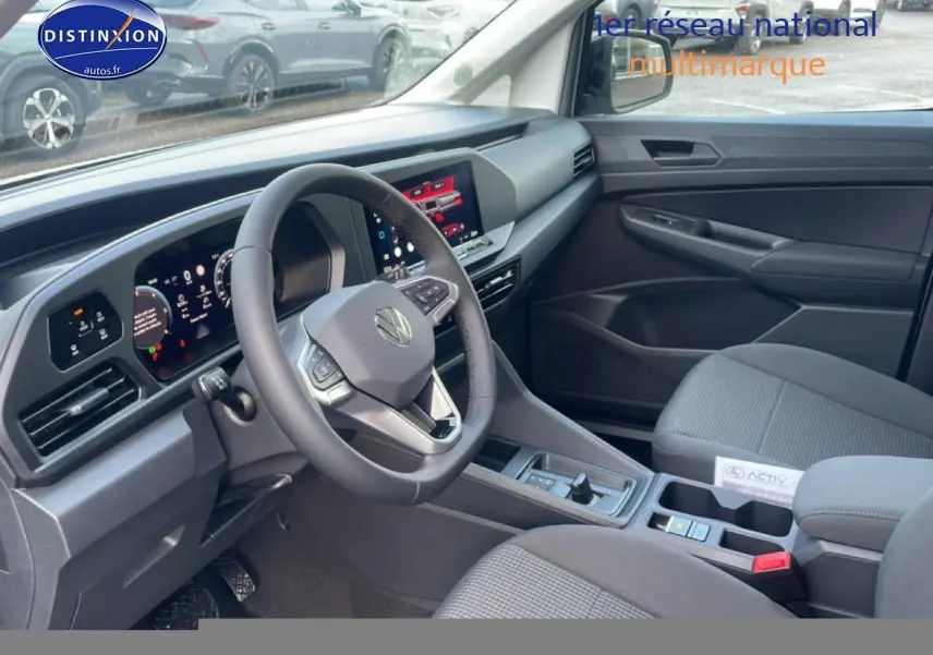 Vue intérieure côté conducteur du Volkswagen Caddy 2.0 TDI 122 DSG7 2025 avec volant cuir multifonction et écran tactile.
