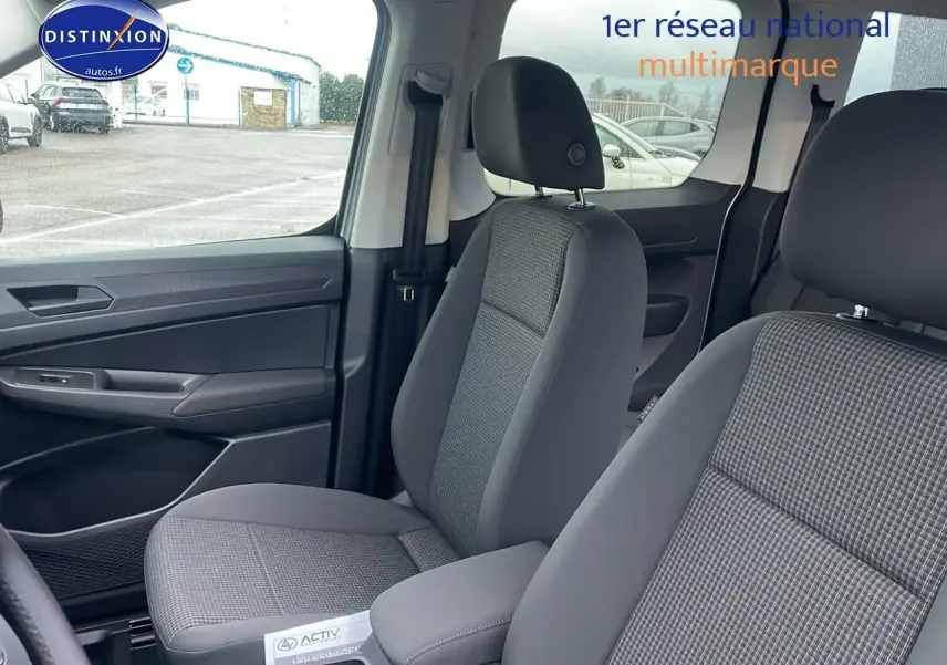 Vue intérieure sur les sièges avant gris tissu à motif double grid du Volkswagen Caddy 2025, côté gauche visible.