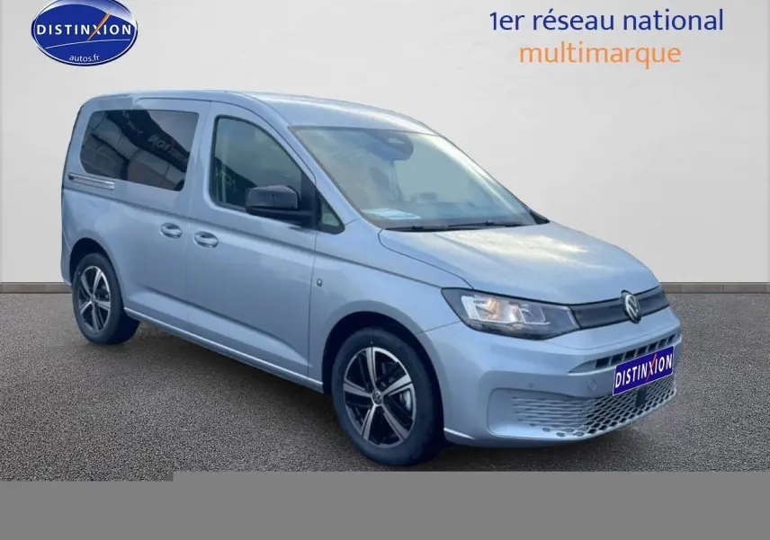 Vue 3/4 avant droit d'un Volkswagen Caddy gris argent 2025 avec jantes alliage et vitres teintées.