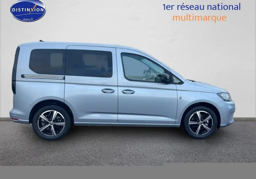 Profil droit d'un Volkswagen Caddy gris argent 2025 avec vitres teintées et jantes alliage noires.