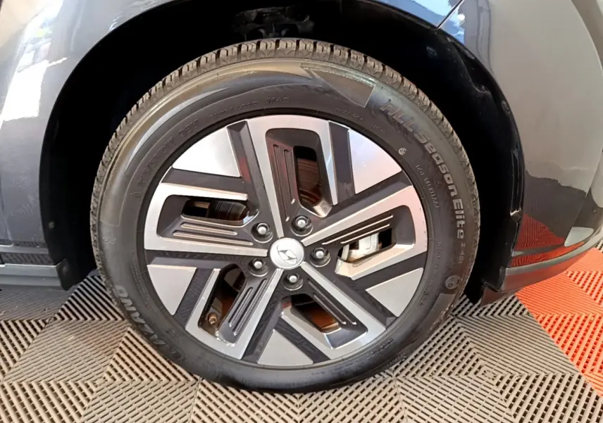 Gros plan sur la roue avant droite d'une Hyundai Kona électrique noire avec jante alliage bicolore moderne.
