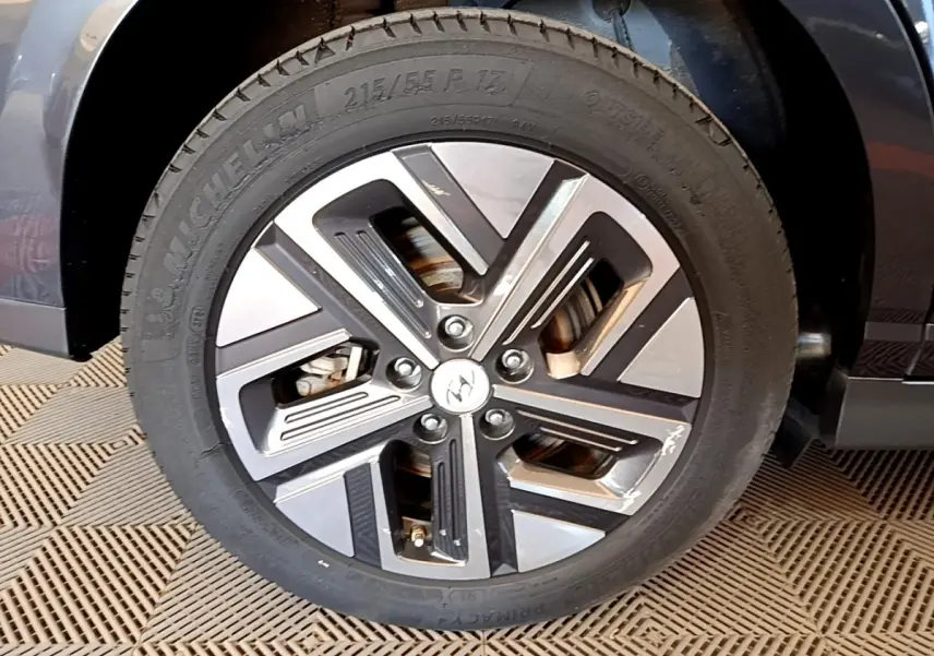 Gros plan sur la roue avant droite du Hyundai Kona électrique 2021, jante alliage bicolore avec logo Hyundai au centre.