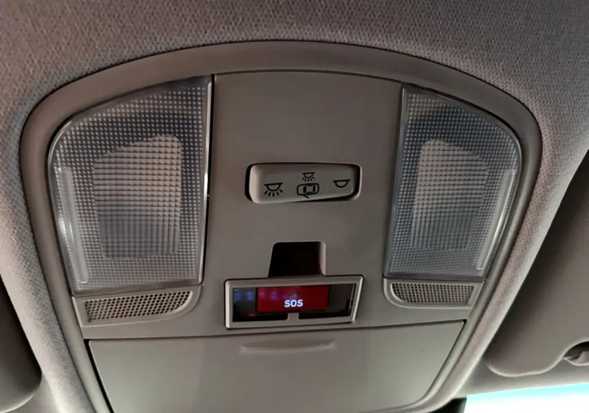 Plafonnier intérieur gris avec boutons d’éclairage et signal SOS du Hyundai Kona électrique, vue en contre-plongée.