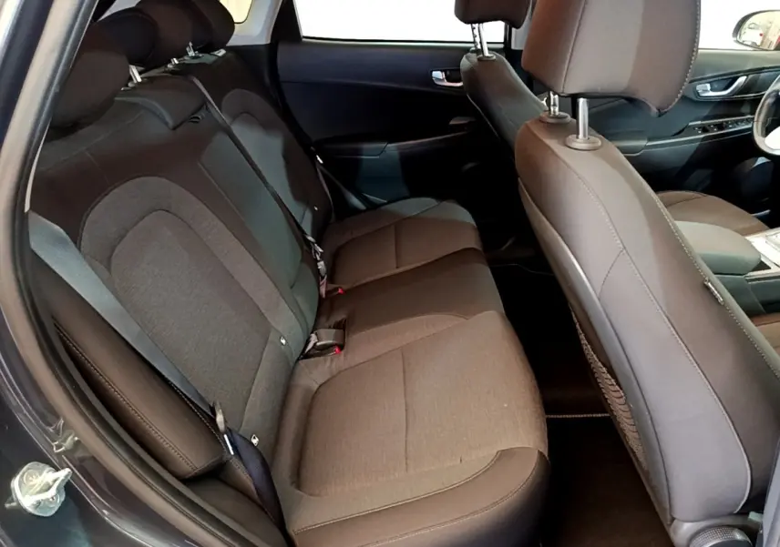 Vue intérieure côté gauche montrant la banquette arrière grise et les sièges avant du Hyundai Kona électrique 2021.