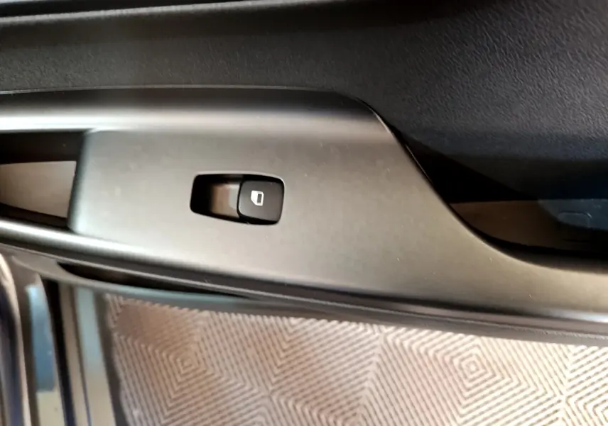 Gros plan sur le bouton de verrouillage des portes côté conducteur du Hyundai Kona électrique, intérieur noir.