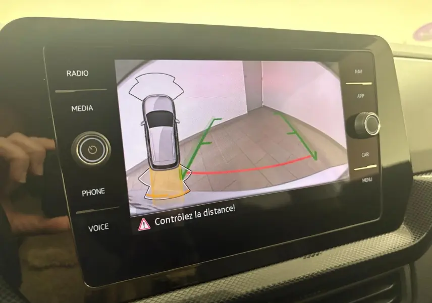 Écran tactile du Volkswagen T-Cross 2024 en reflet d'argent montrant la caméra de recul avec aides visuelles au stationnement.
