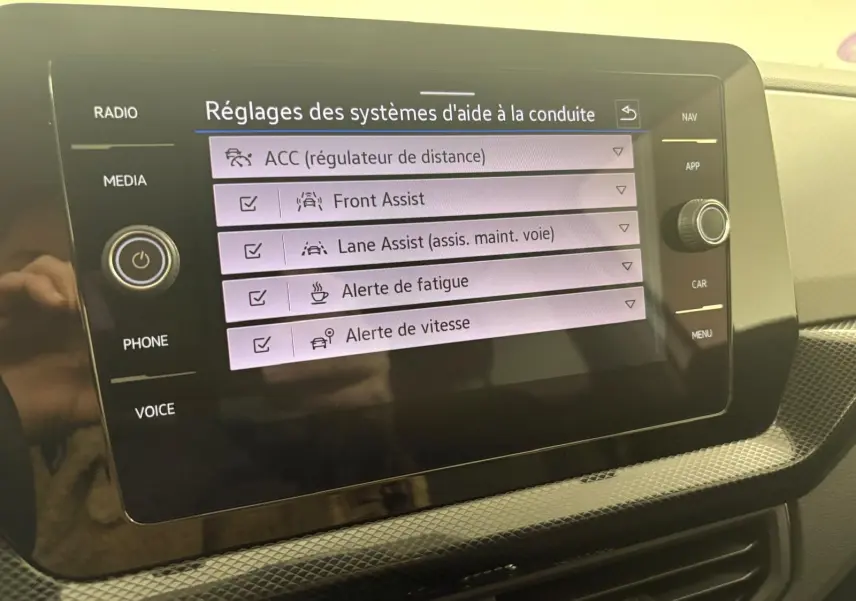Écran tactile central du Volkswagen T-Cross 2024 affichant les réglages d'aide à la conduite en intérieur.