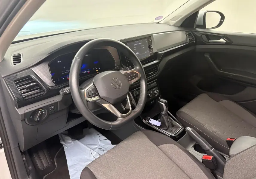 Intérieur avant droit du Volkswagen T-Cross 2024 argent, volant cuir multifonction et écran tactile central.