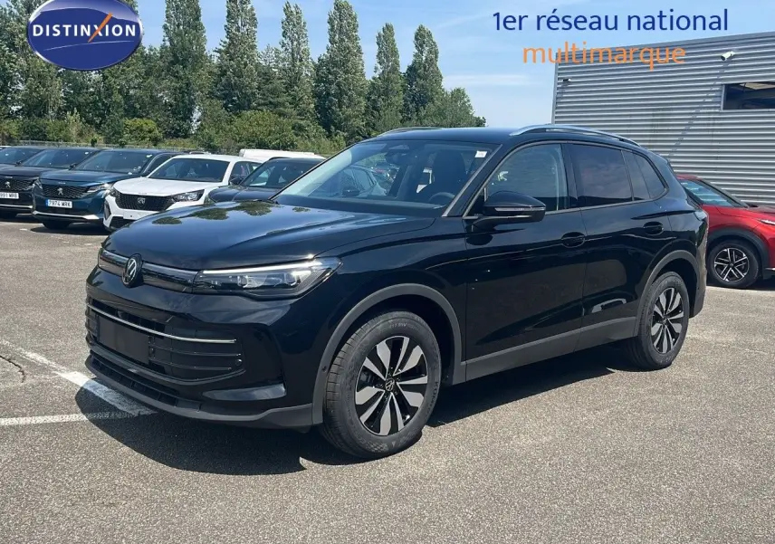 Volkswagen Tiguan noir Grenadilla 3/4 avant droit, roues alliage et calandre épurée sous un ciel bleu.