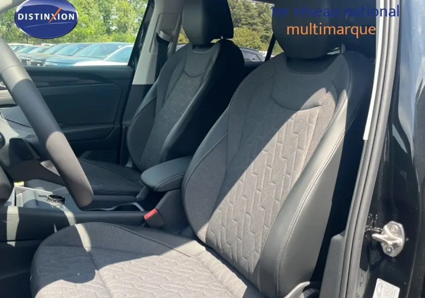 Vue intérieure côté avant droit du Volkswagen Tiguan noir Grenadilla, mettant en valeur les sièges tissu et cuir gris.