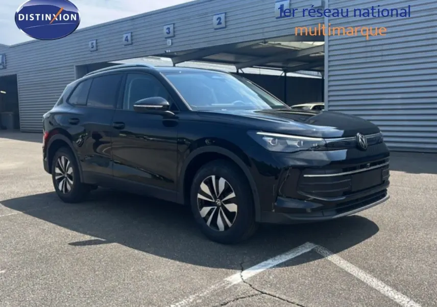 Volkswagen Tiguan noir Grenadilla métal en 3/4 avant droit, avec jantes bi-ton et calandre moderne.