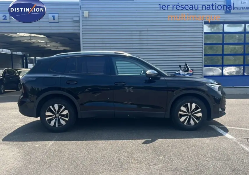Vue latérale droite du Volkswagen Tiguan noir Grenadilla 2026, SUV compact avec jantes alliage distinctives.