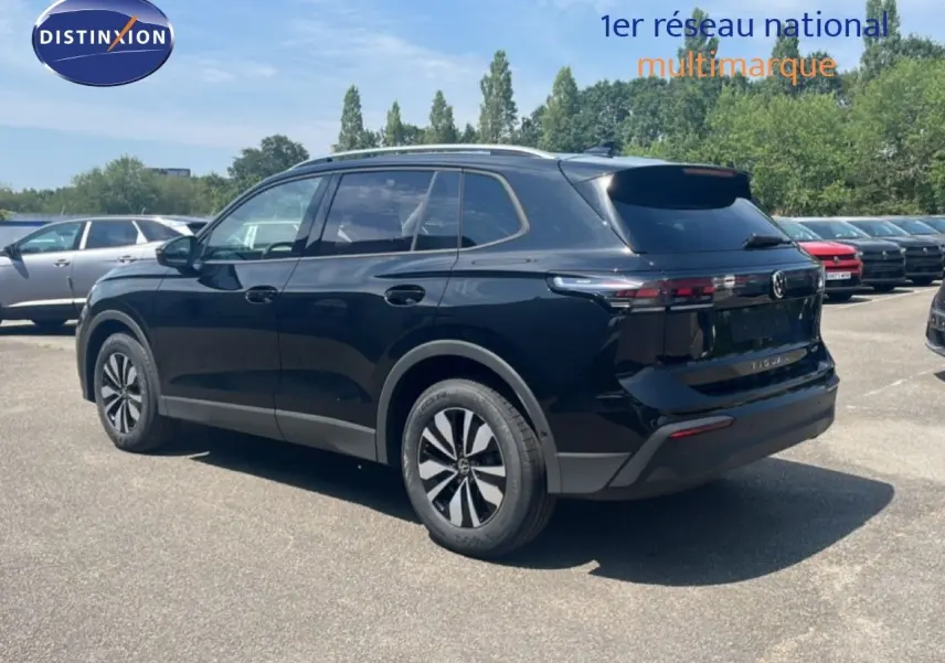 Vue 3/4 arrière droite d'un Volkswagen Tiguan noir Grenadilla métallisé, avec jantes alliage et feux arrière LED.