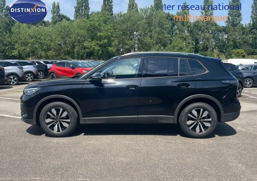 Profil latéral droit du Volkswagen Tiguan noir Grenadilla métallisé, avec jantes alliage et lignes épurées visibles.