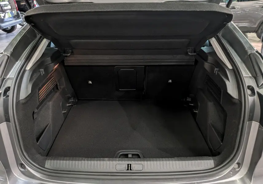 Coffre ouvert vu de l'arrière d'une Citroën C4 Hybride gris Mercury, montrant un espace de rangement propre et spacieux.