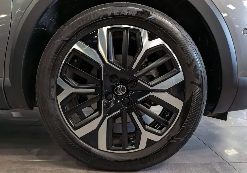 Gros plan sur la jante biton noir et argent de la Citroën C4 Hybride gris Mercury, avec pneu Goodyear visible.