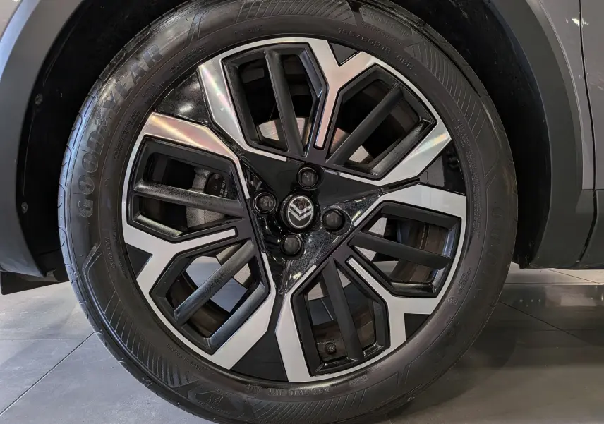 Gros plan sur la roue avant droite de la Citroën C4 hybride gris Mercury avec jante bi-ton noire et argent.