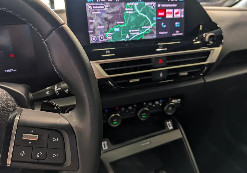 Vue intérieure côté conducteur du tableau de bord noir avec écran tactile affichant la navigation sur Citroën C4 hybride 2025.