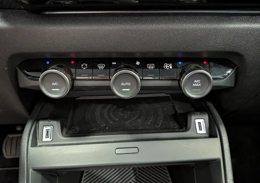 Vue rapprochée de la console centrale de la Citroën C4 Hybride 2025, montrant les commandes de climatisation et ports USB.