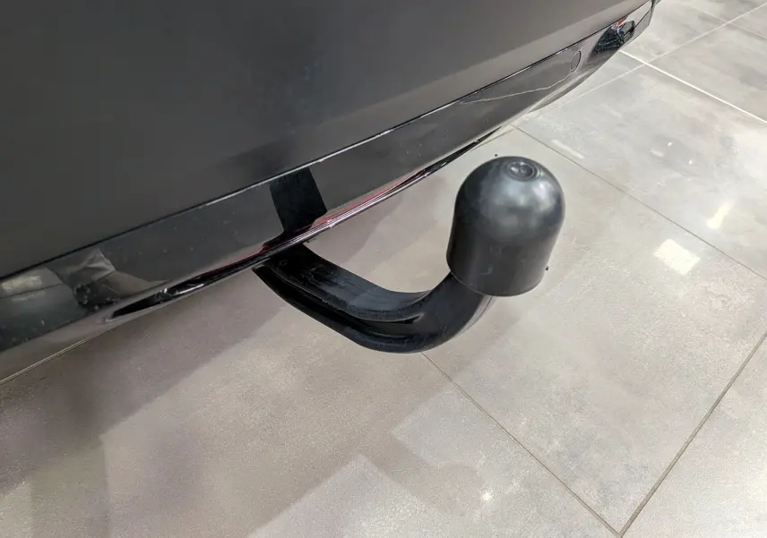 Gros plan sur l'attelage d'une Citroën C4 gris Mercury, visible sous le pare-chocs arrière sur sol carrelé.