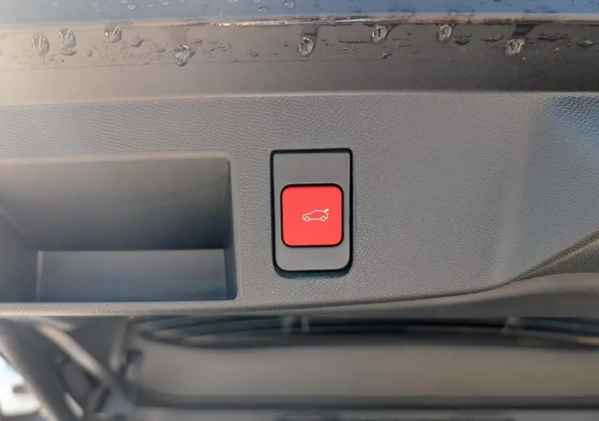 Bouton rouge d'ouverture électrique du hayon sur la partie intérieure d'un Citroën C5 Aircross blanc.