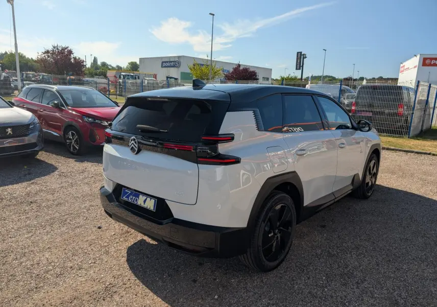 Vue 3/4 arrière droite du Citroën C5 Aircross blanc avec toit noir et jantes alliage noires sur parking.