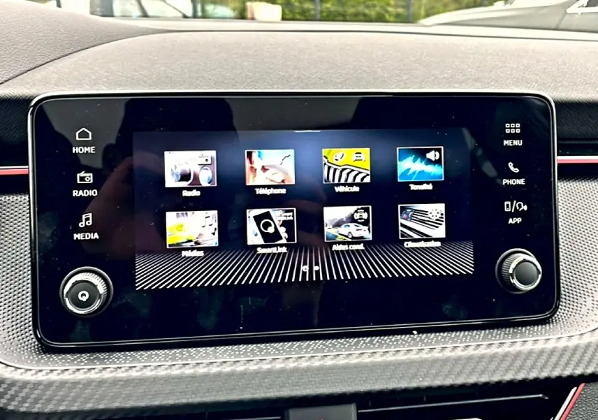 Écran tactile central du Skoda Kamiq blanc nacré 2026 avec interface multimédia et commandes autour.