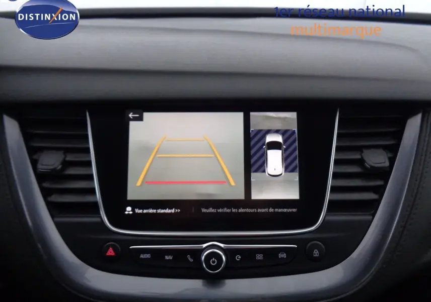 Écran central de l’Opel Grandland X blanc nacré montrant l’affichage caméra de recul et vue aérienne du véhicule.