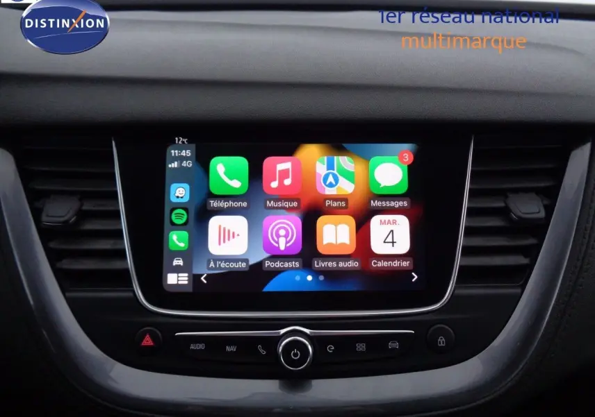 Écran tactile central avec interface Apple CarPlay dans l'habitacle d'un Opel Grandland X blanc nacré hybride rechargeable.