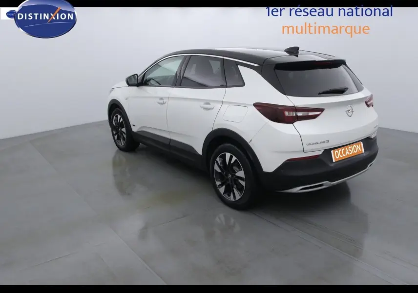 Opel Grandland X hybride blanc nacré vu en 3/4 arrière droit avec toit noir et jantes alliage noires.