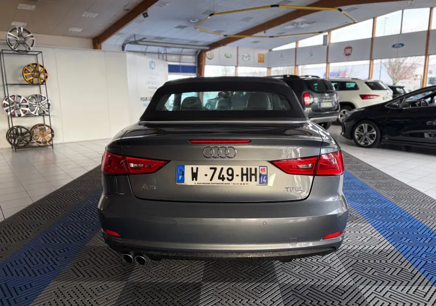 Intérieur de l'Audi A3 Cabriolet gris 2014, vue côté gauche, sièges en cuir noir et tableau de bord moderne.