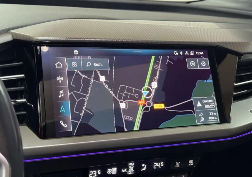 Écran tactile central du tableau de bord de l'Audi Q4 E-TRON gris foncé, affichant la navigation GPS en vue satellite.