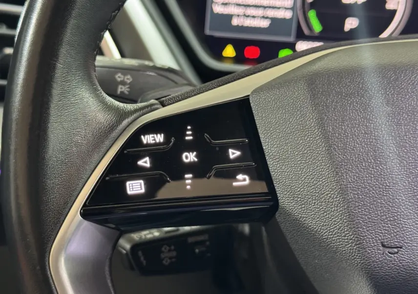 Gros plan sur les commandes tactiles gauche du volant cuir noir d’un Audi Q4 E-TRON 2022 électrique.