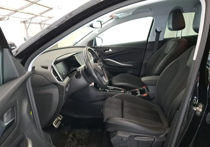Vue 3/4 arrière droite d'un Opel Grandland noir 2023 avec jantes alliage bicolores et vitres teintées.