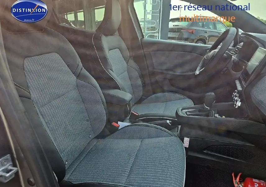 Vue intérieure côté gauche de la Renault Clio V 1.6 e-tech 145 techno avec sièges sport gris et accoudoir central.